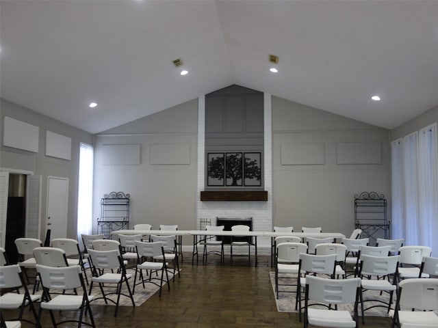 dining space featuring a fireplace and lofted ceiling