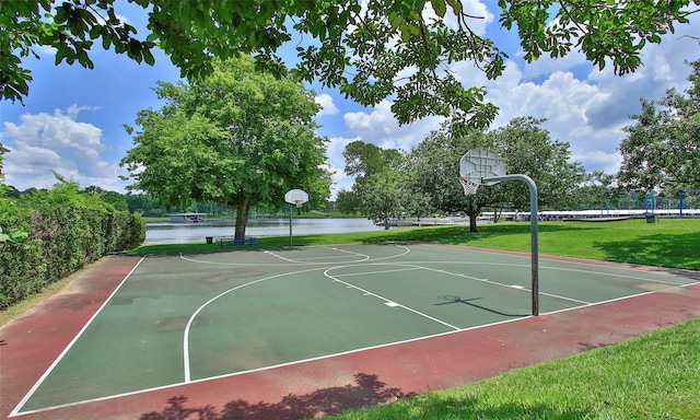 view of basketball court featuring a yard and a water view