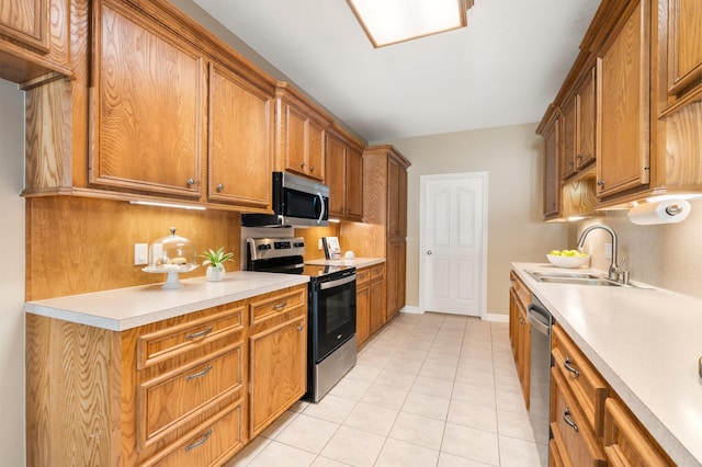 kitchen featuring light tile patterned floors, stainless steel appliances, and sink