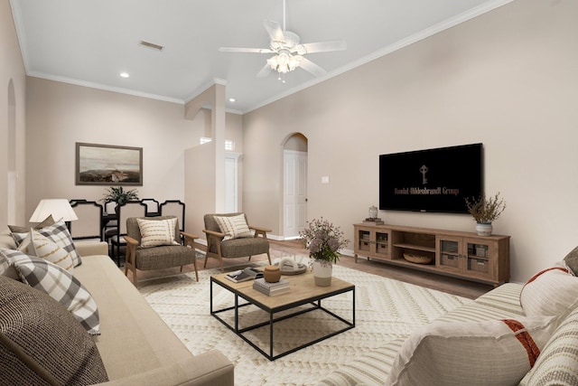 living room with ceiling fan, light wood-type flooring, and ornamental molding