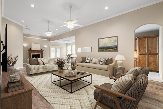 living room featuring hardwood / wood-style floors, ceiling fan, and crown molding