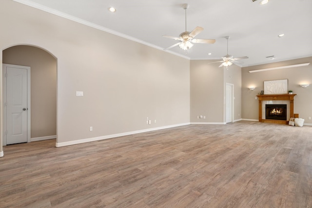 unfurnished living room with ceiling fan, crown molding, and light hardwood / wood-style floors