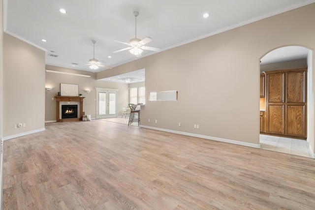 unfurnished living room featuring light hardwood / wood-style flooring, ceiling fan, and crown molding