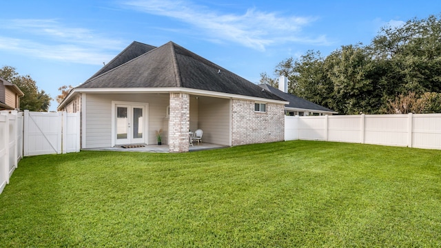 back of property with a patio area, a yard, and french doors