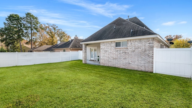 rear view of property with a yard