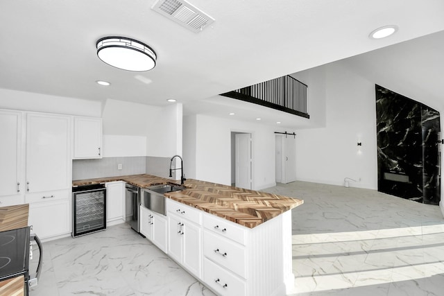 kitchen with kitchen peninsula, beverage cooler, sink, dishwasher, and white cabinetry