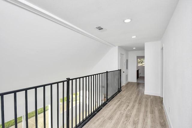 hallway with light hardwood / wood-style flooring and a healthy amount of sunlight