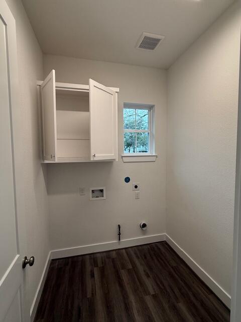 laundry area with cabinets, gas dryer hookup, hookup for a washing machine, dark hardwood / wood-style floors, and hookup for an electric dryer