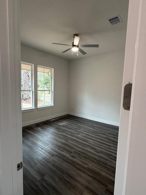 unfurnished room featuring ceiling fan and dark wood-type flooring