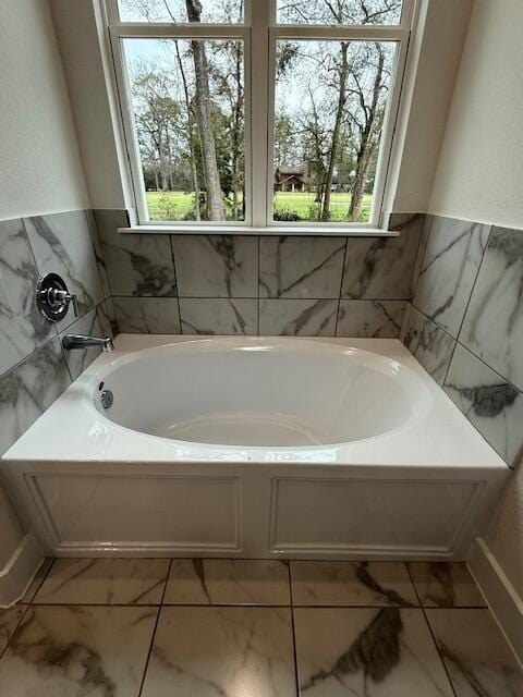 bathroom featuring a wealth of natural light and a bathtub