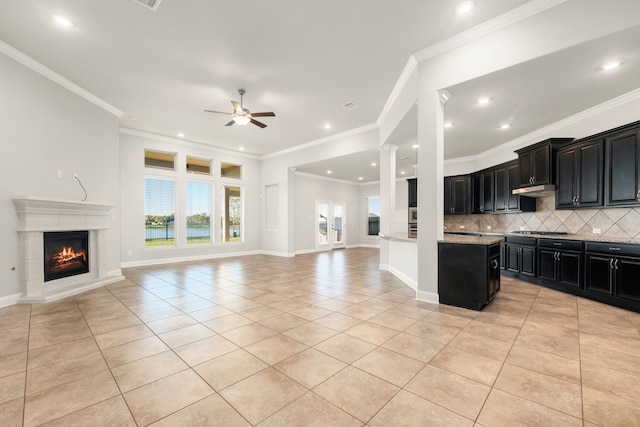 kitchen featuring ceiling fan, a center island, ornamental molding, and light tile patterned floors