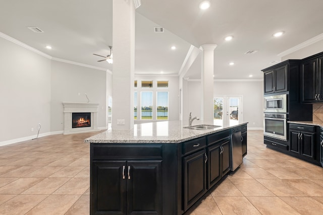 kitchen featuring decorative columns, ornamental molding, stainless steel appliances, ceiling fan, and sink