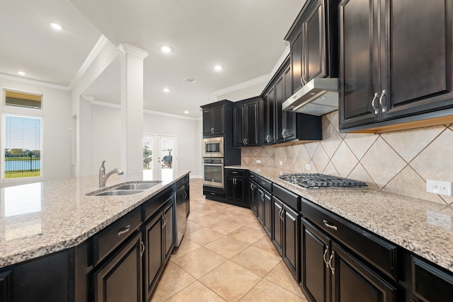 kitchen with light stone countertops, ornamental molding, sink, and appliances with stainless steel finishes