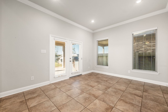 tiled spare room with ornamental molding and french doors