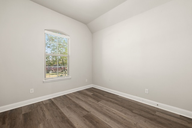 spare room featuring dark hardwood / wood-style flooring and lofted ceiling