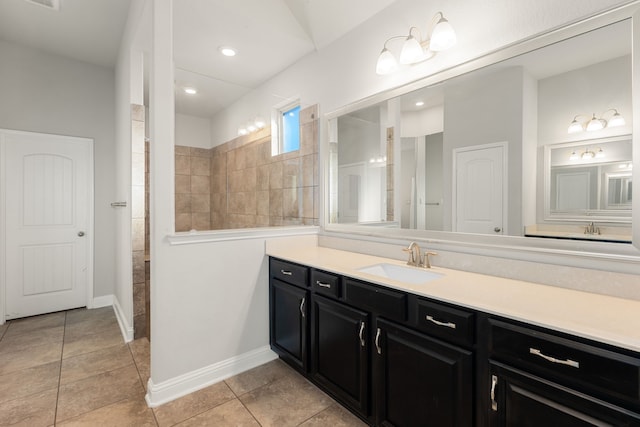 bathroom featuring tile patterned floors, vanity, and a tile shower