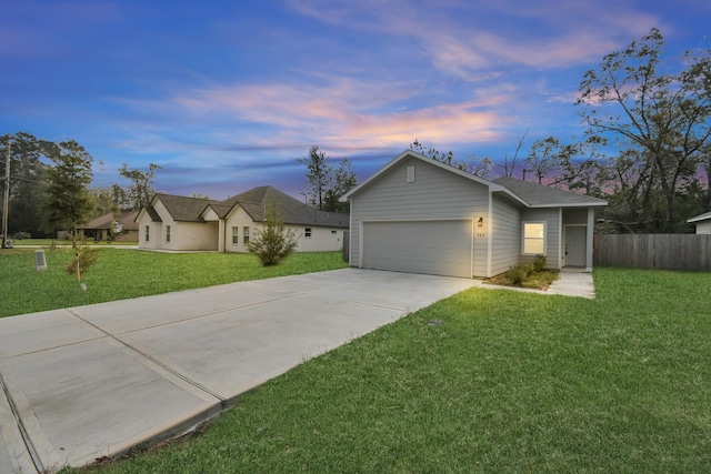 ranch-style home featuring a garage and a lawn