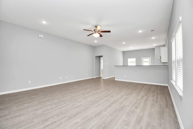 unfurnished living room with ceiling fan, a healthy amount of sunlight, and light hardwood / wood-style floors