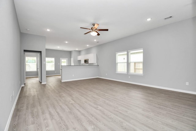 unfurnished living room featuring light wood-type flooring and ceiling fan