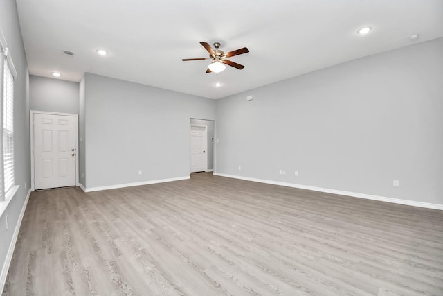 empty room with ceiling fan and light hardwood / wood-style floors