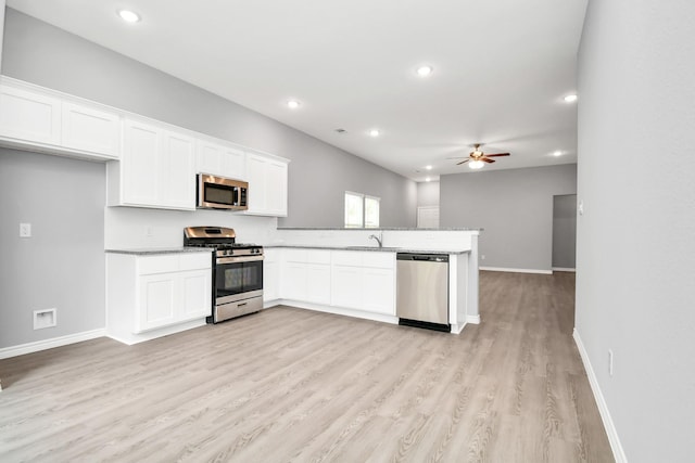 kitchen with white cabinetry, sink, ceiling fan, stainless steel appliances, and kitchen peninsula