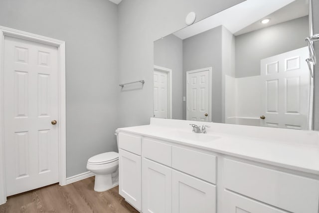 bathroom with hardwood / wood-style flooring, vanity, and toilet