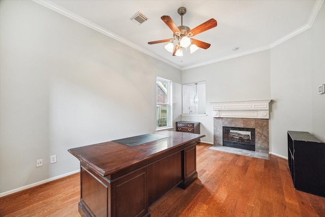 office space with ceiling fan, a fireplace, wood-type flooring, and crown molding