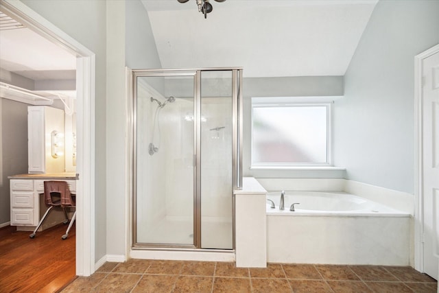 bathroom with wood-type flooring, plus walk in shower, and vaulted ceiling