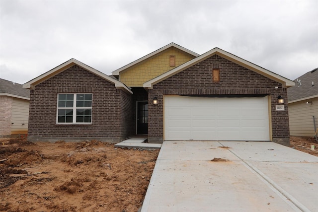 single story home with brick siding, driveway, and a garage