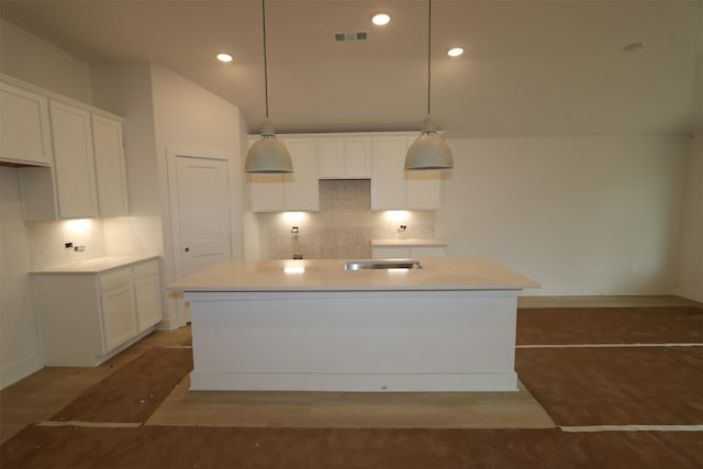 kitchen with tasteful backsplash, white cabinets, and wood finished floors