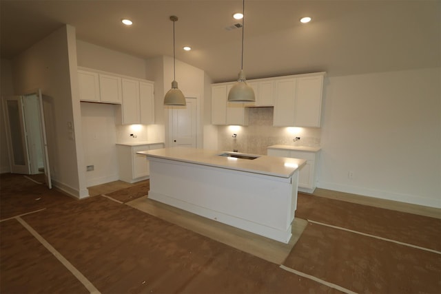 kitchen featuring a sink, tasteful backsplash, and white cabinetry