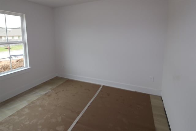 unfurnished room featuring baseboards