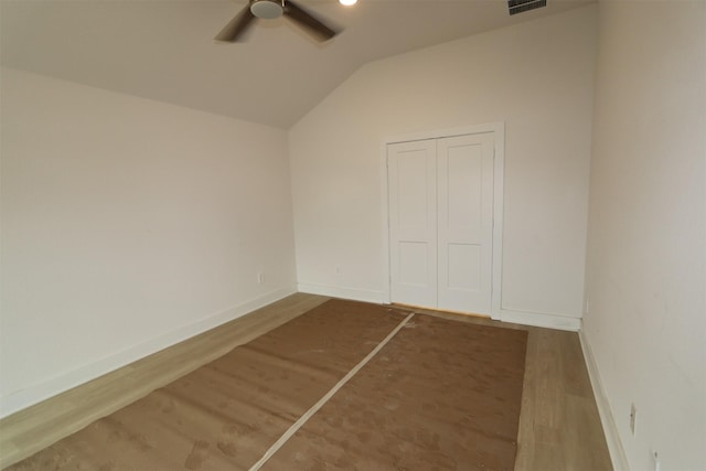 spare room featuring baseboards, a ceiling fan, lofted ceiling, and wood finished floors