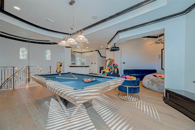 recreation room featuring ornamental molding, light wood-type flooring, a textured ceiling, and billiards