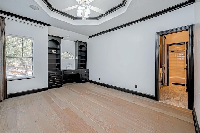 unfurnished bedroom featuring light hardwood / wood-style floors, a raised ceiling, ceiling fan, and crown molding