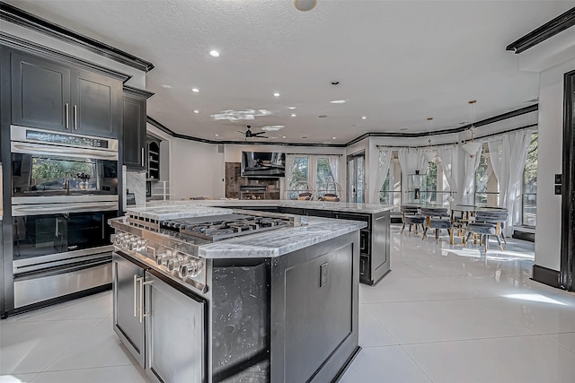 kitchen with crown molding, a center island, ceiling fan, and plenty of natural light