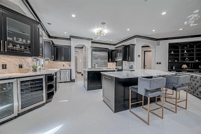 kitchen with a center island, sink, stainless steel appliances, tasteful backsplash, and light tile patterned flooring