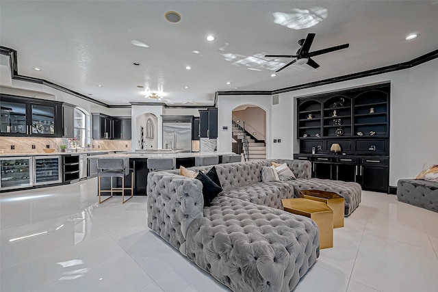 tiled living room featuring ceiling fan, crown molding, and beverage cooler