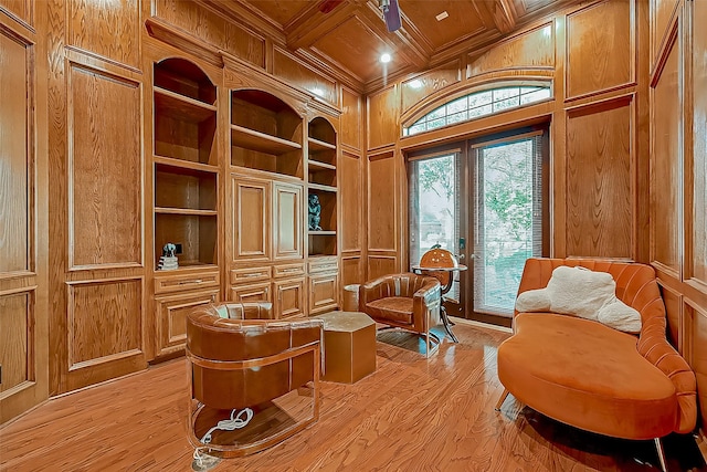 sitting room with wood walls, light hardwood / wood-style flooring, beamed ceiling, and coffered ceiling