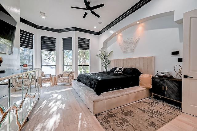 bedroom with ceiling fan, crown molding, and light hardwood / wood-style floors