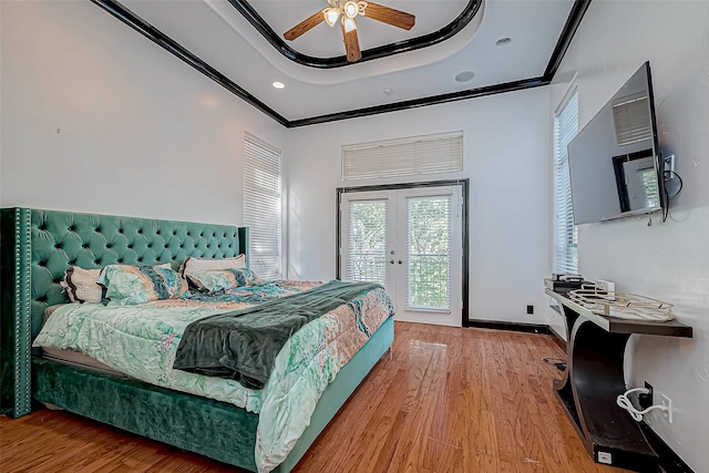 bedroom with access to exterior, ornamental molding, a tray ceiling, ceiling fan, and light hardwood / wood-style flooring