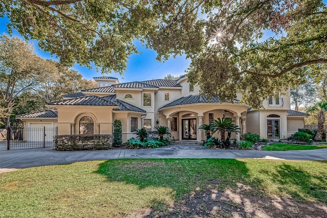 mediterranean / spanish-style home featuring a front yard and a garage