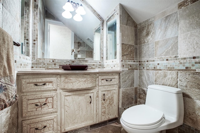 bathroom featuring tile walls, vanity, and vaulted ceiling