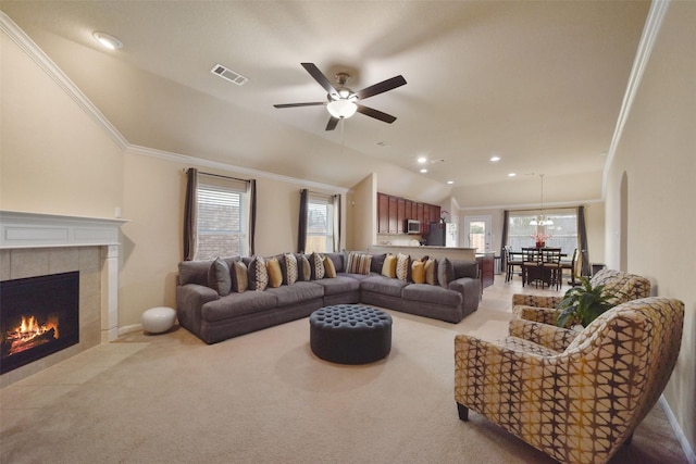 carpeted living room featuring a fireplace, ceiling fan, crown molding, and vaulted ceiling