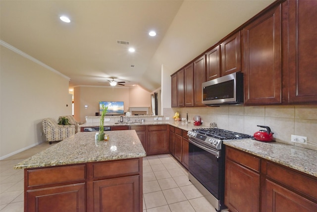 kitchen featuring a kitchen island, lofted ceiling, crown molding, and appliances with stainless steel finishes