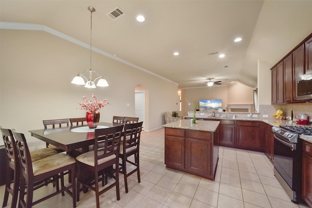 kitchen with pendant lighting, lofted ceiling, crown molding, light stone countertops, and appliances with stainless steel finishes