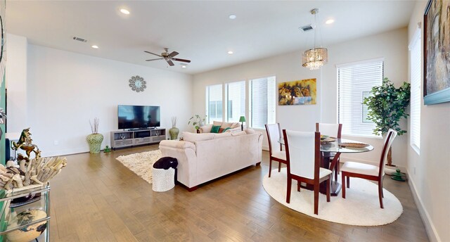 living room with ceiling fan and dark wood-type flooring