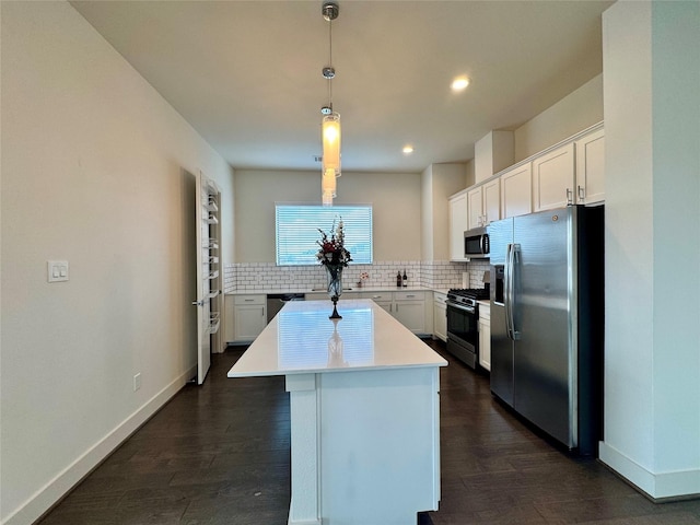 kitchen with a center island, appliances with stainless steel finishes, white cabinets, pendant lighting, and backsplash