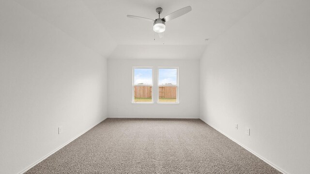 carpeted spare room featuring ceiling fan and vaulted ceiling