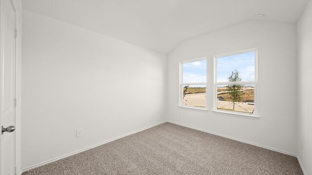 unfurnished room featuring carpet floors and lofted ceiling